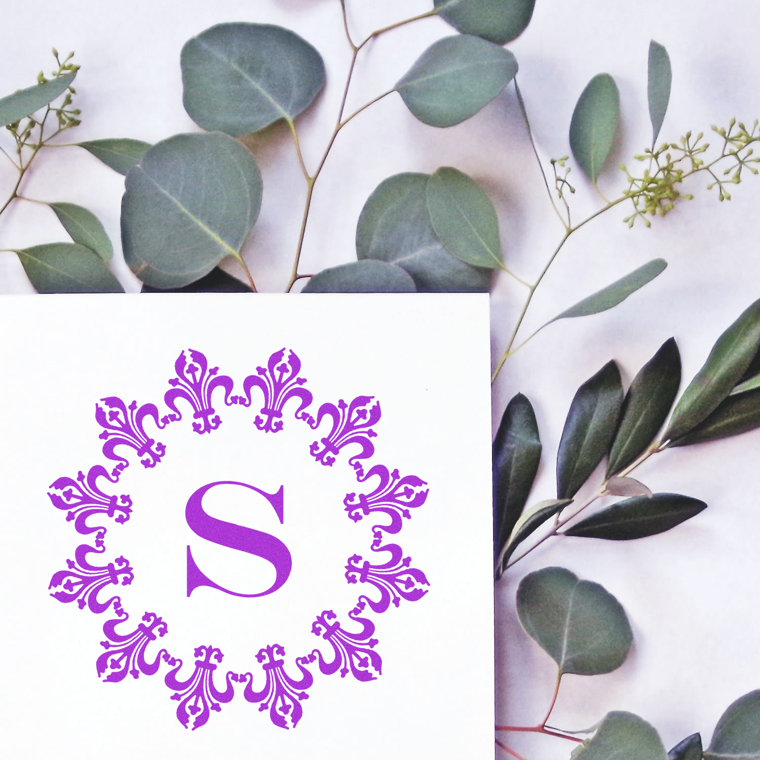 Purple monogram S rubber stamp with ornate floral border, ideal for wedding stationery and personalized branding.