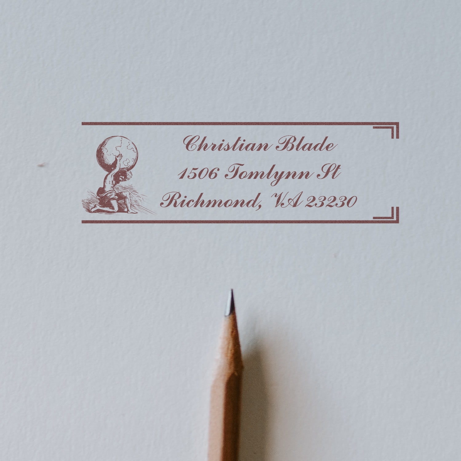 Custom rubber address stamp impression with globe design, showing Christian Blade address in Richmond, VA on paper.
