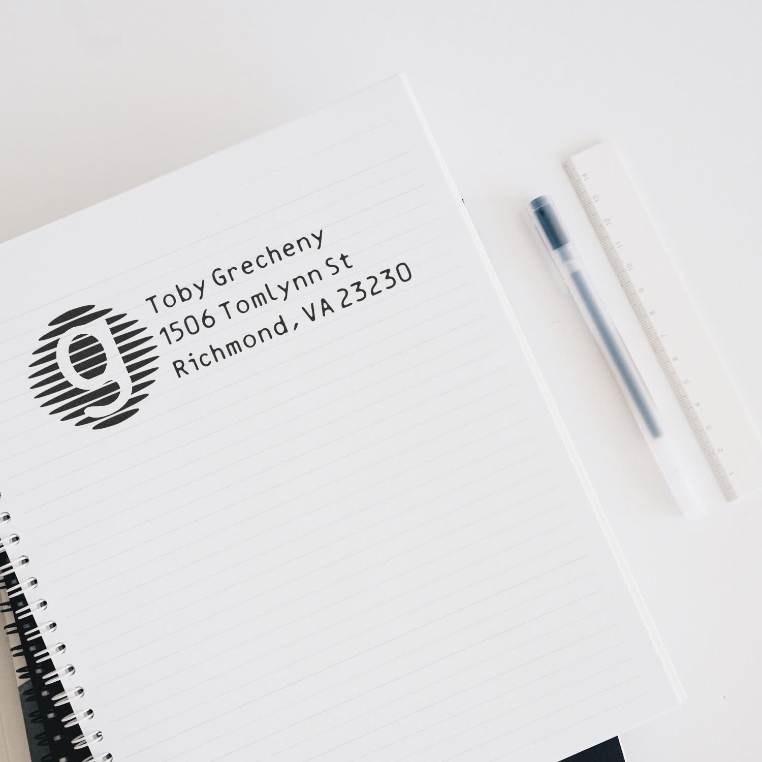 Custom return address rubber stamp imprint on notebook page, ideal for personalized stationery and business mail.