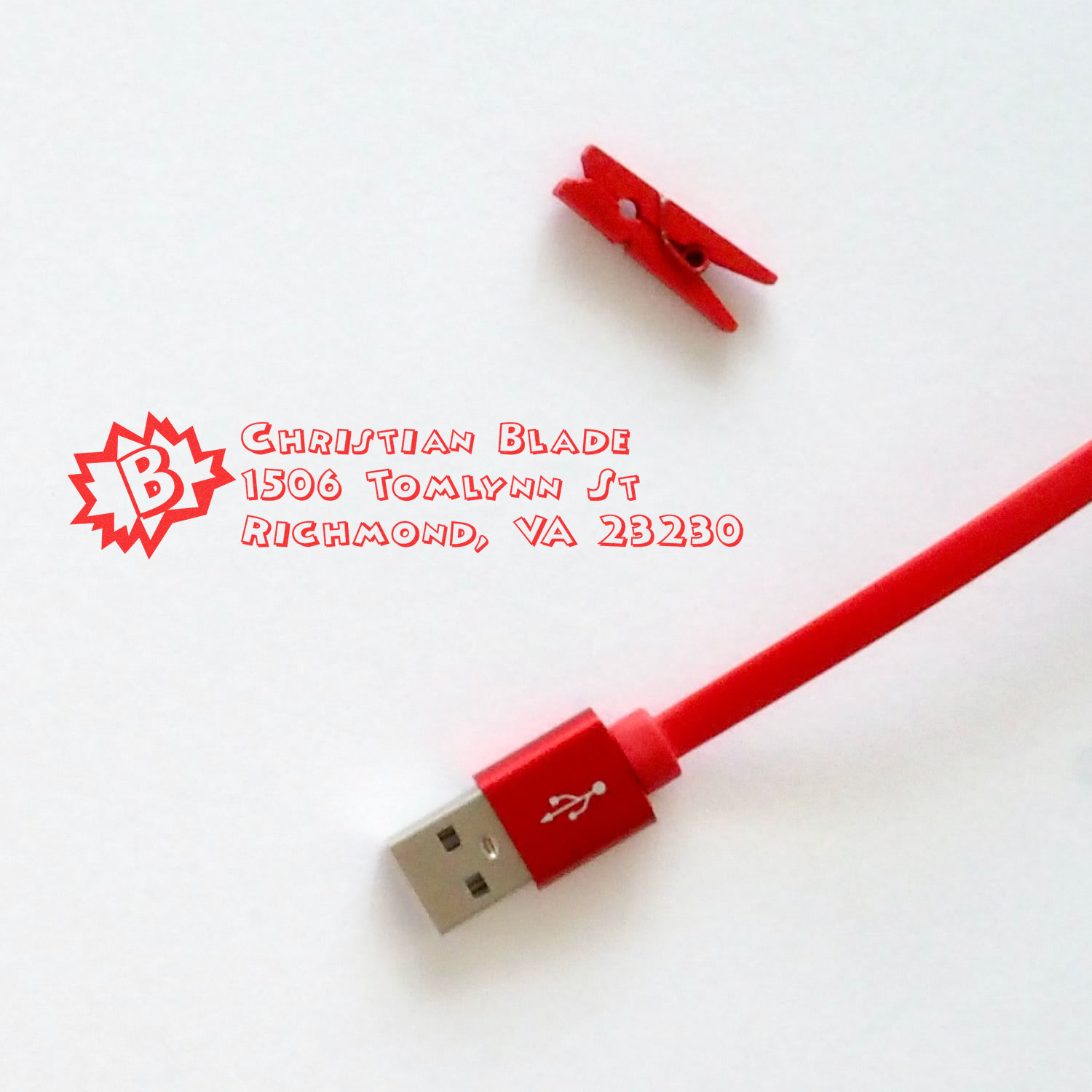 Custom rubber stamp imprint with Christian Blade address and logo, shown beside a red USB cable on white background.