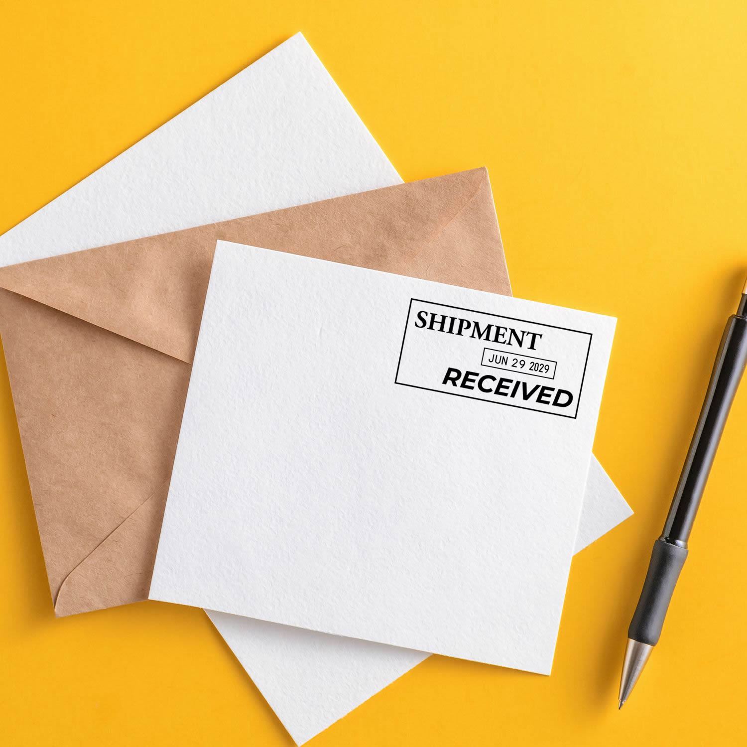 Shipping envelopes with Shipment Received stamp and pen on yellow background.