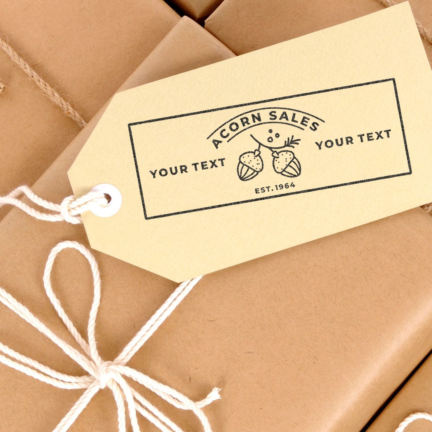 Custom kraft gift tag with Acorn Sales logo tied to brown wrapped package with white twine.