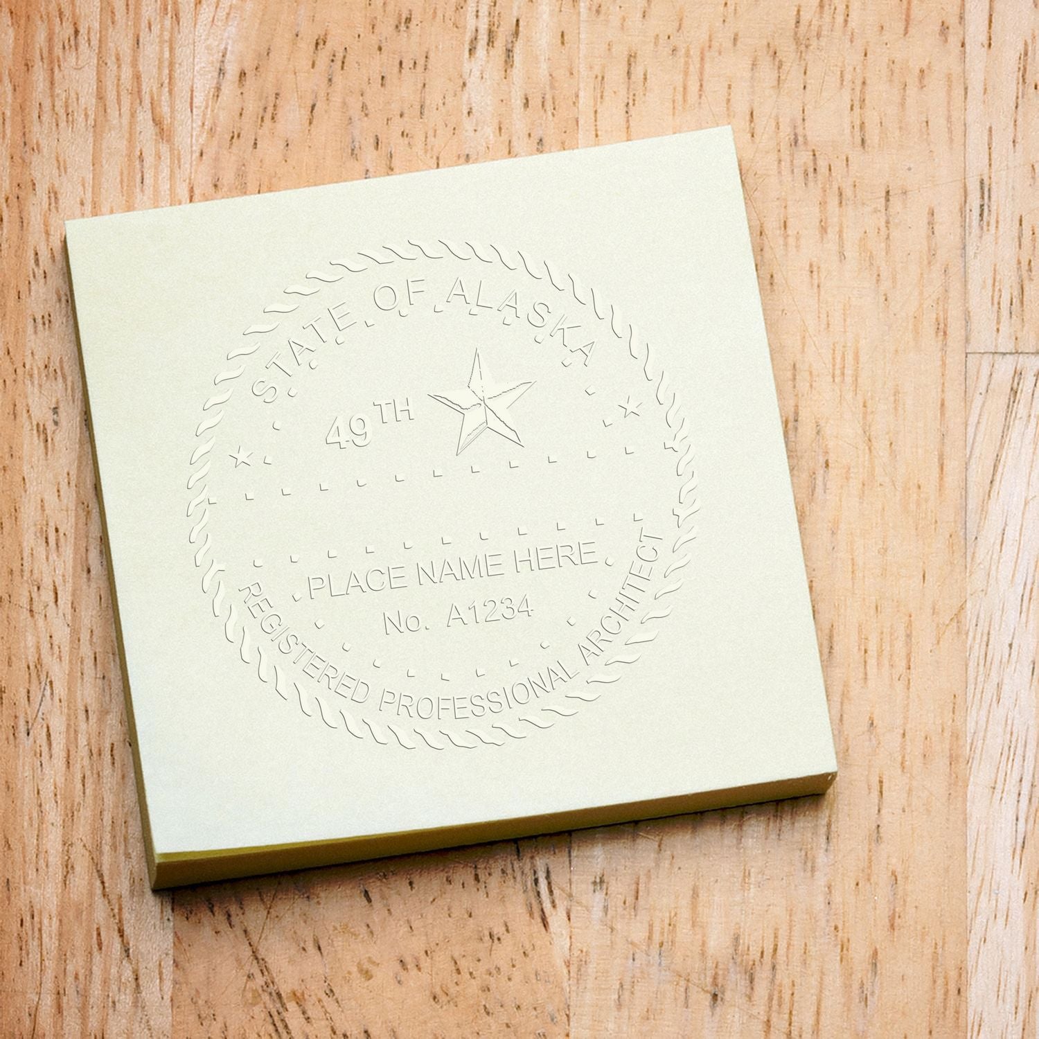Embossed Alaska State seal on a cream card mockup, professional logo and branding design on a wooden background.