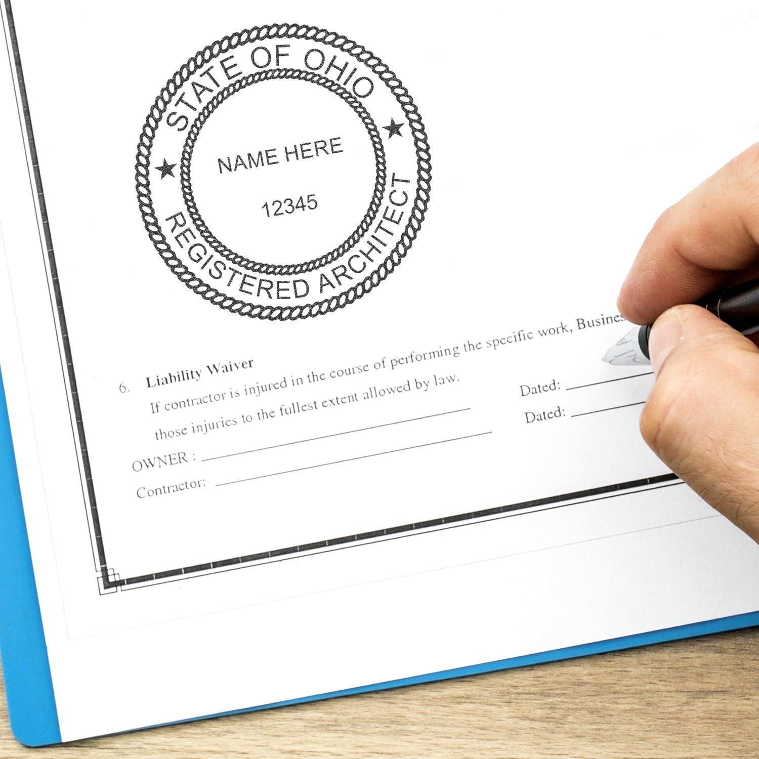 Hand signing a construction contract with a State of Ohio registered architect seal stamp on the document.