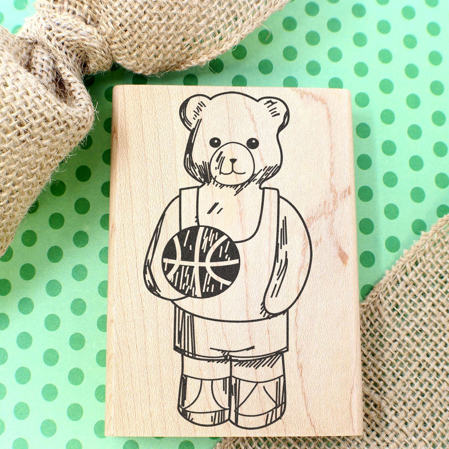 Wooden teddy bear basketball stamp on green polka dot background with burlap fabric accents