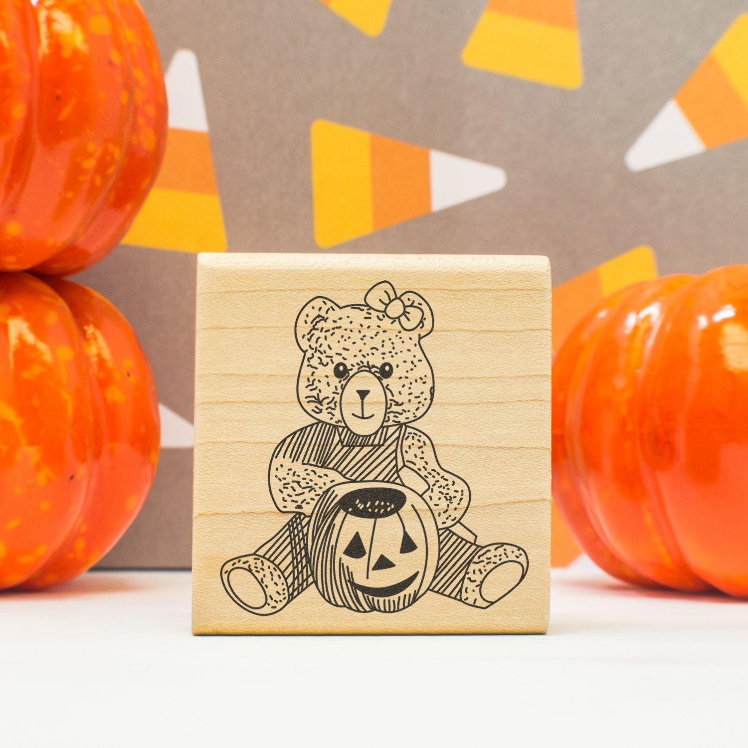 Halloween teddy bear pumpkin wooden stamp with orange pumpkins and festive fall decor