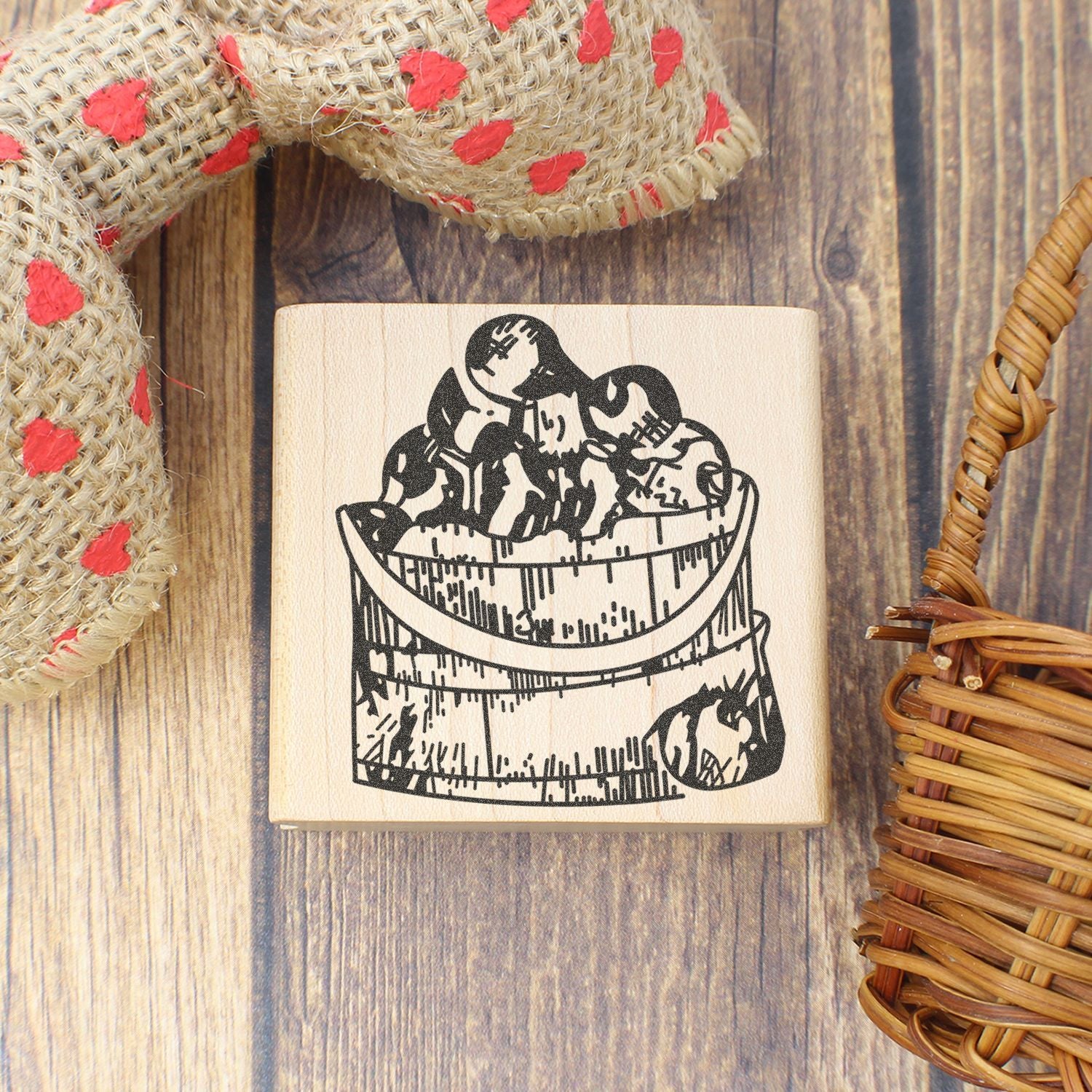 Rustic wooden rubber stamp with a basket of apples design on a wood background.