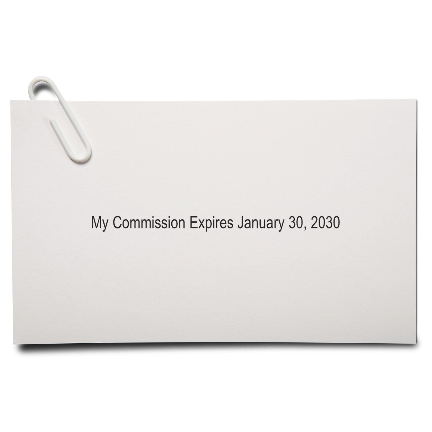 White paper note with paperclip reading My Commission Expires January 30, 2030 on a clean background.