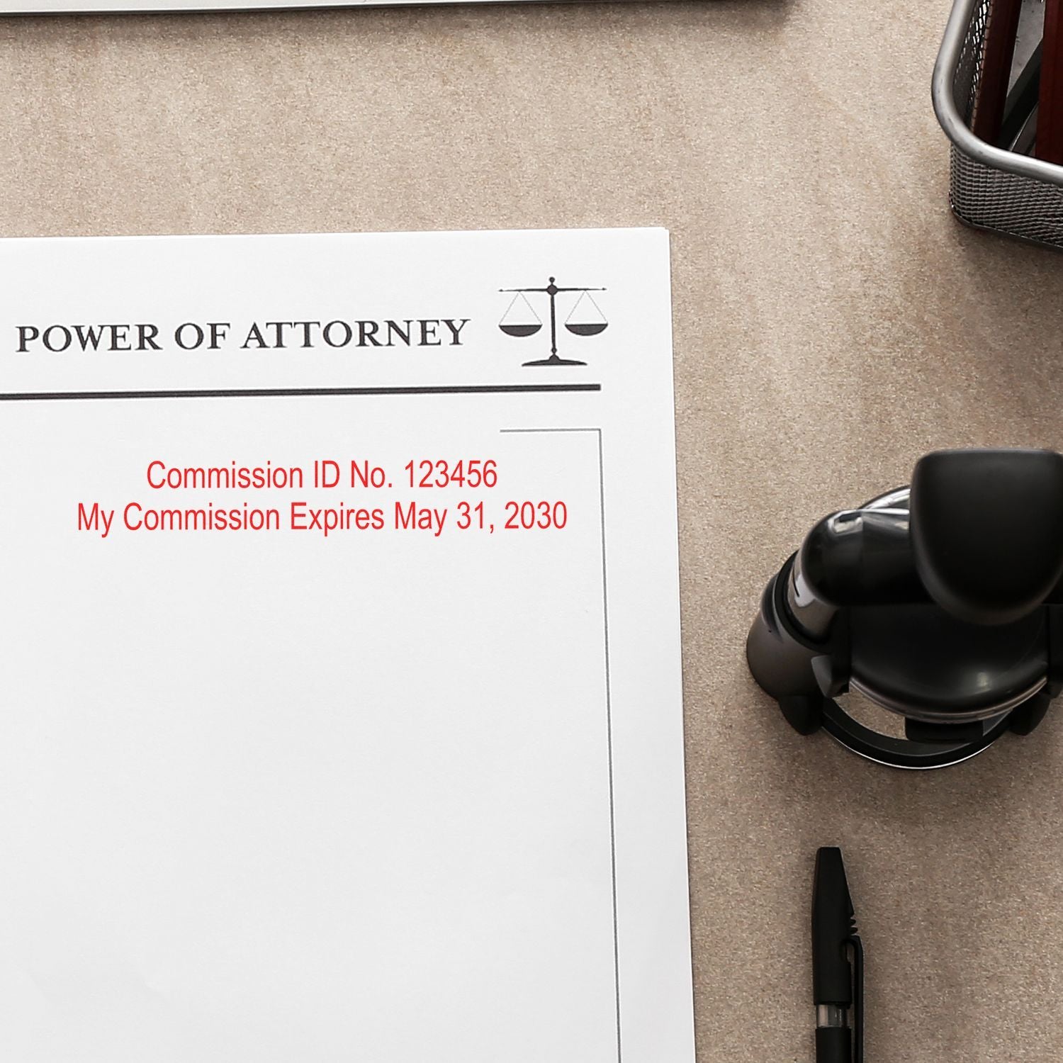 Power of attorney document with notary commission details, stamp, and pen on desk.