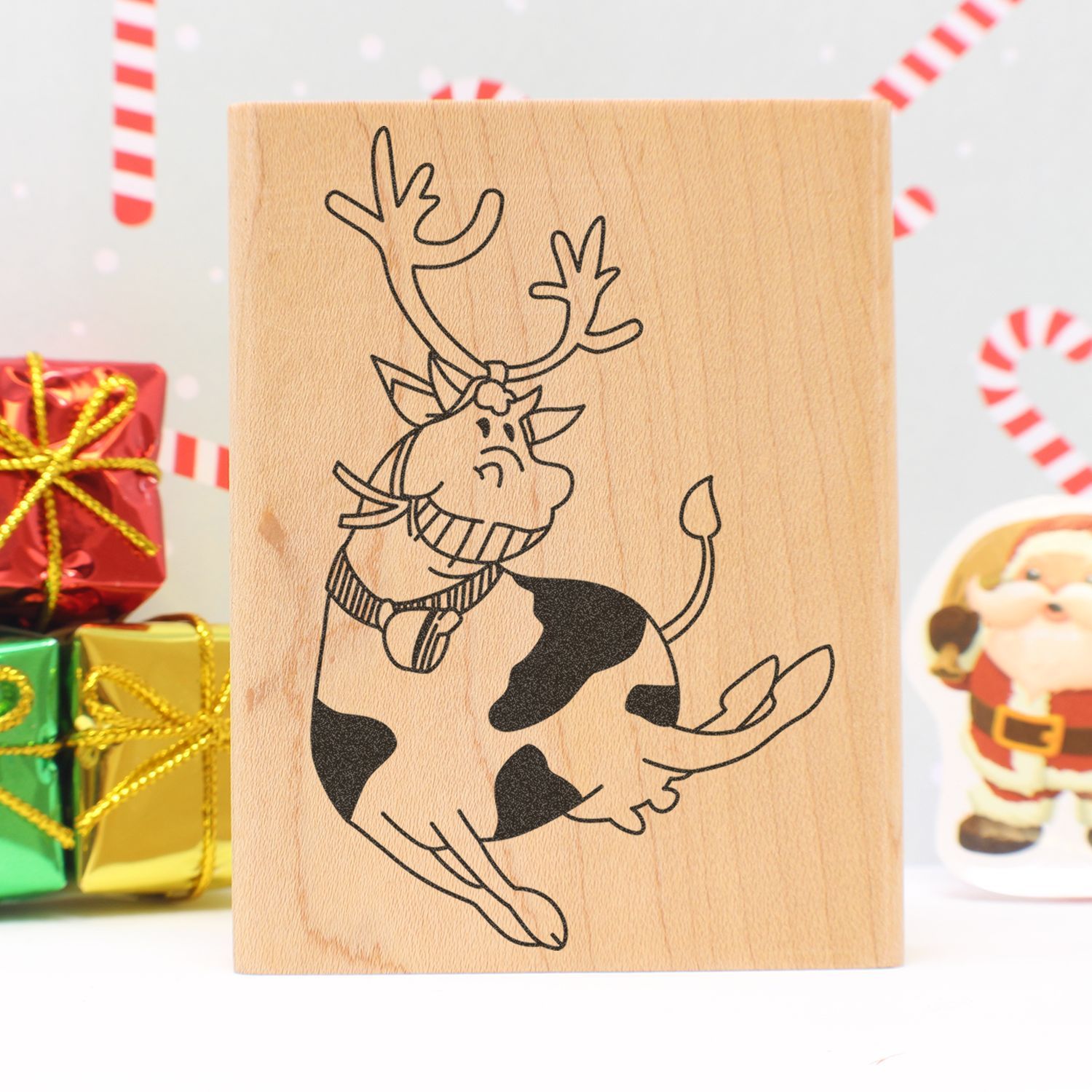 Wooden reindeer stamp with Christmas gift boxes and festive holiday decor background.