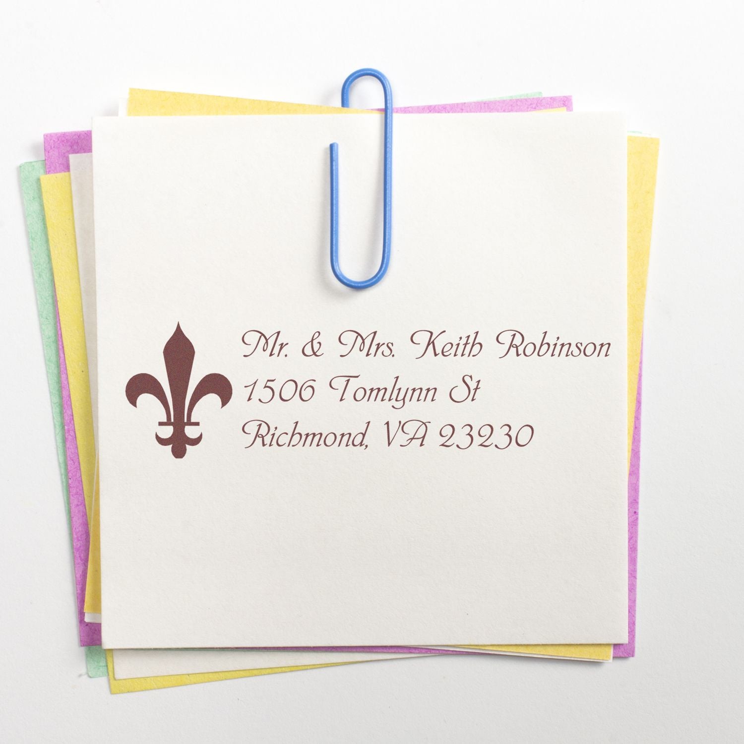 Personalized return address rubber stamp on stationery, featuring a fleur-de-lis design for wedding invitations and custom mail.