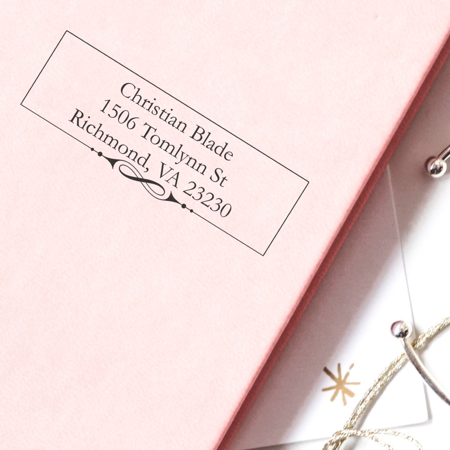 Personalized return address rubber stamp on pink notebook, featuring Christian Blade, Richmond, VA 23230.