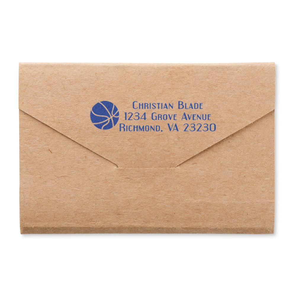 Custom address rubber stamp on kraft envelope with basketball logo, showing blue return address for business mail.