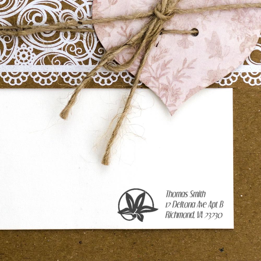 Custom address rubber stamp on wedding envelope with floral design, twine tie, and handmade gift packaging.