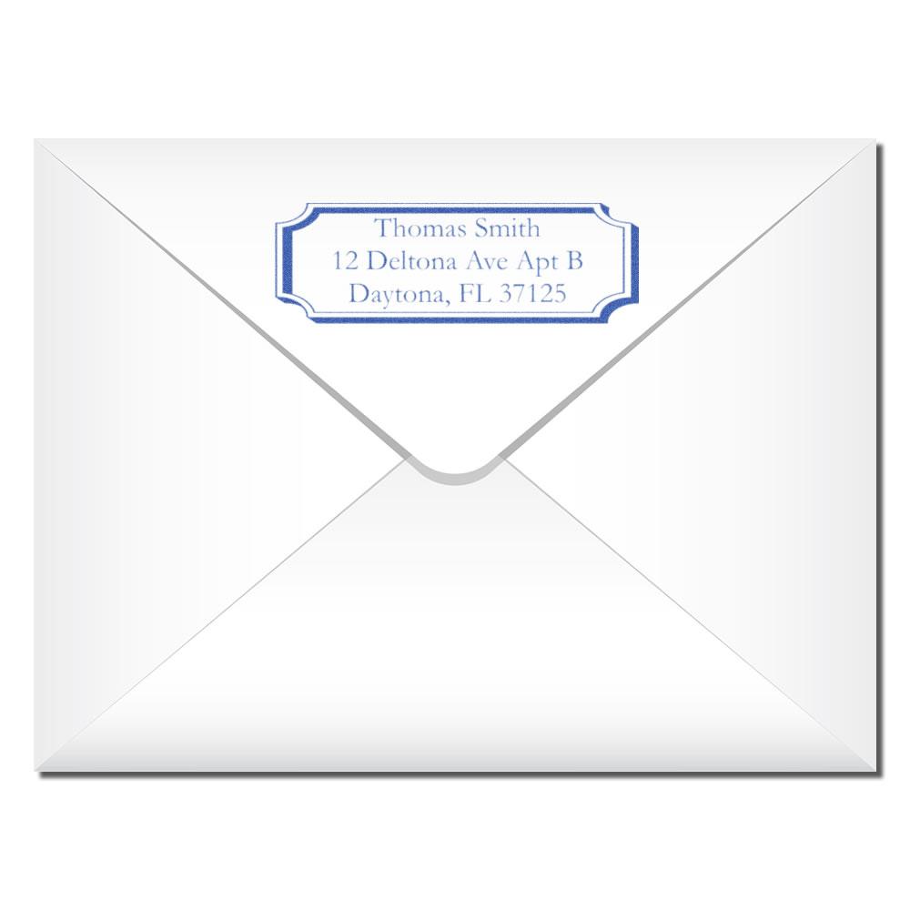 Custom return address rubber stamp on envelope with blue framed label for mailing and personal correspondence.