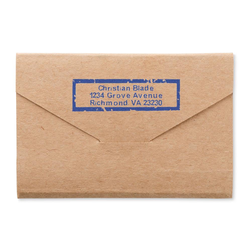 Custom address rubber stamp on kraft envelope with blue return address imprint for mailing and branding.