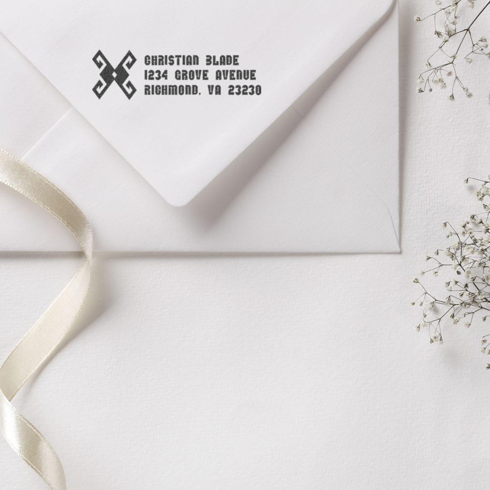Custom return address rubber stamp on a white envelope for wedding invitations and personal mail.