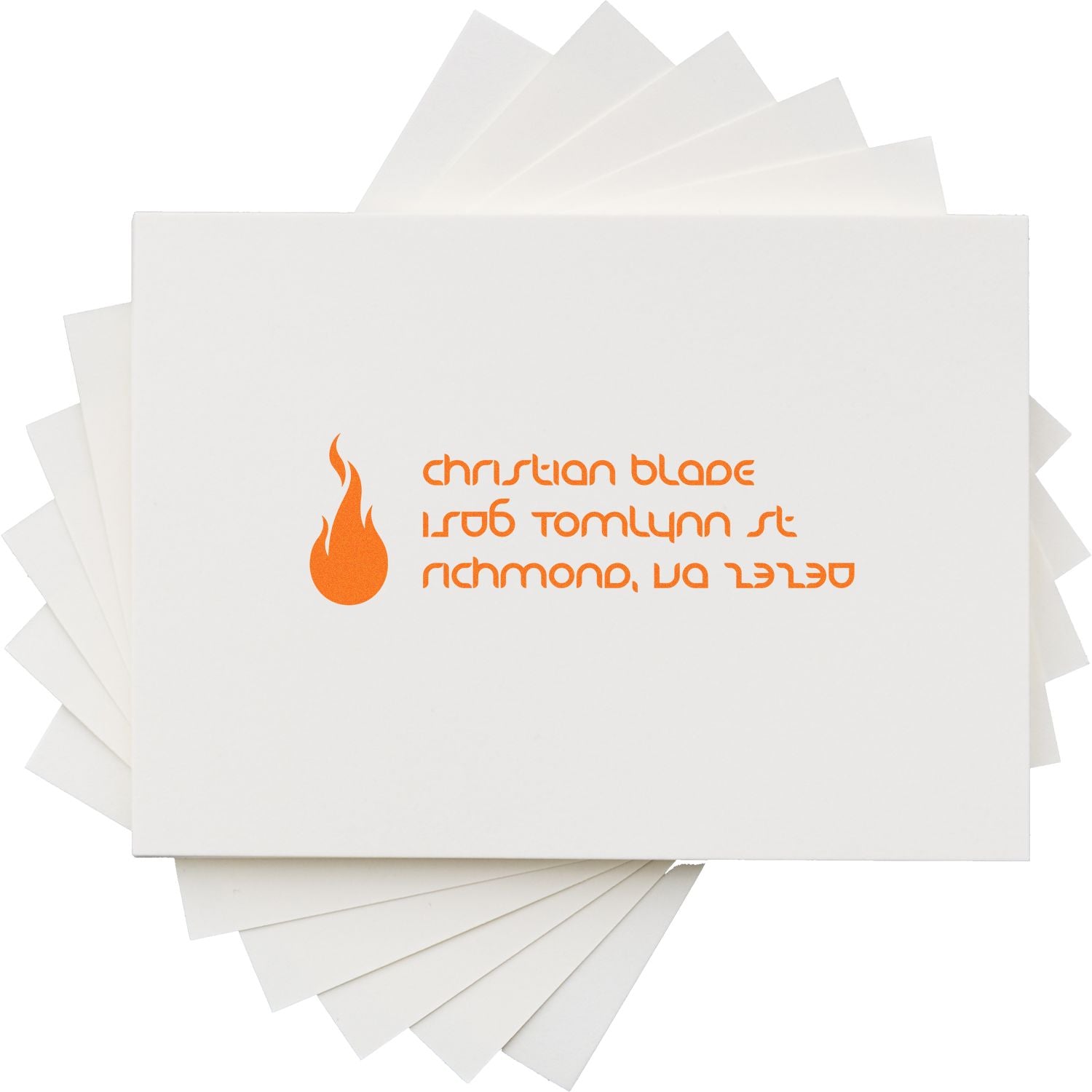 Custom rubber stamp imprint with orange flame logo and Christian Blade address on white paper stack.