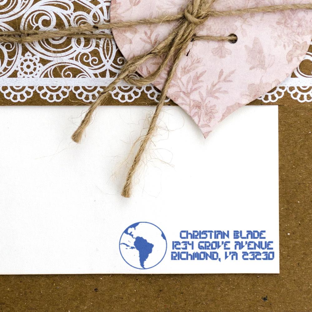 Custom return address rubber stamp with globe logo on white envelope for handmade mailings