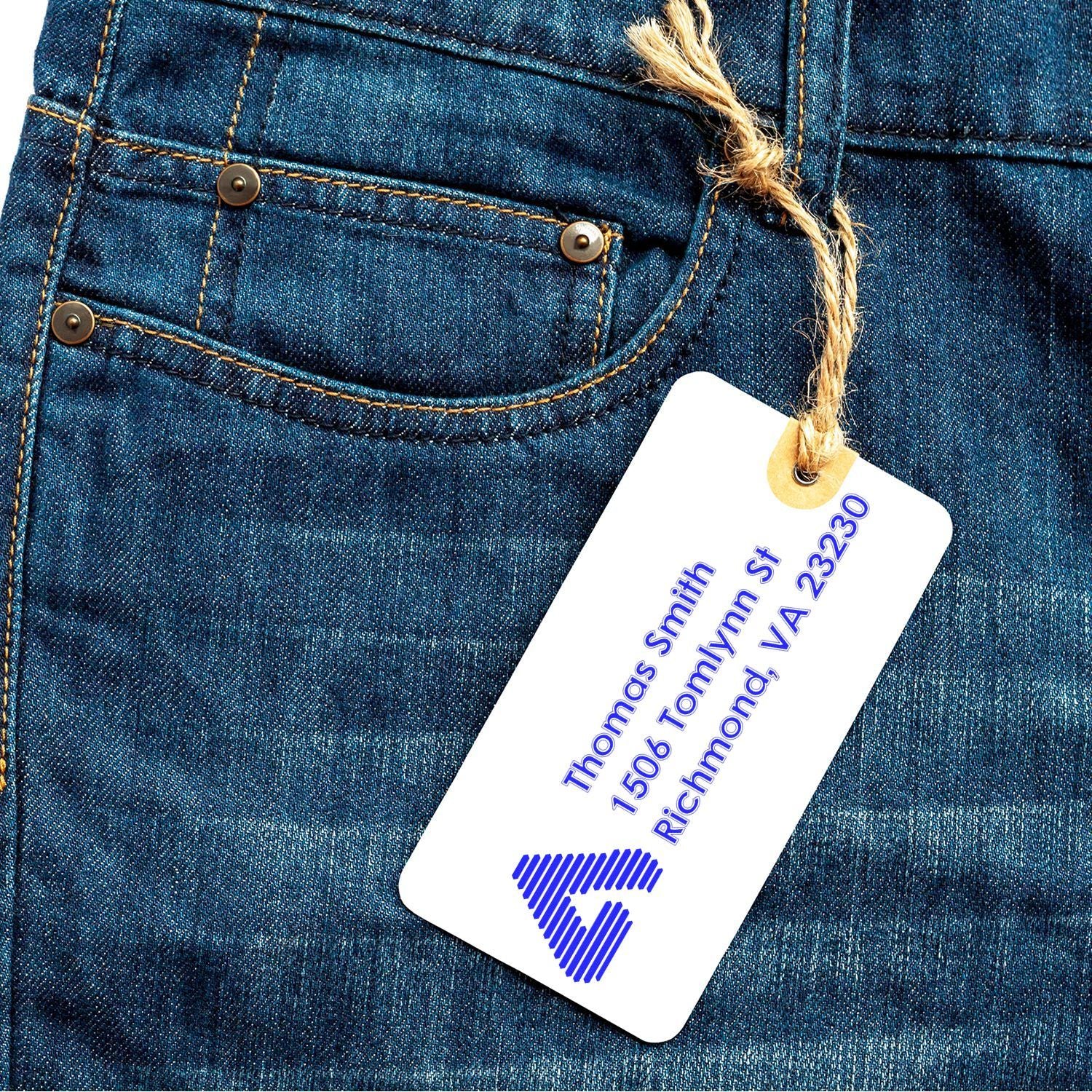Custom return address rubber stamp on a hanging jeans tag for personalized branding and mailing labels.