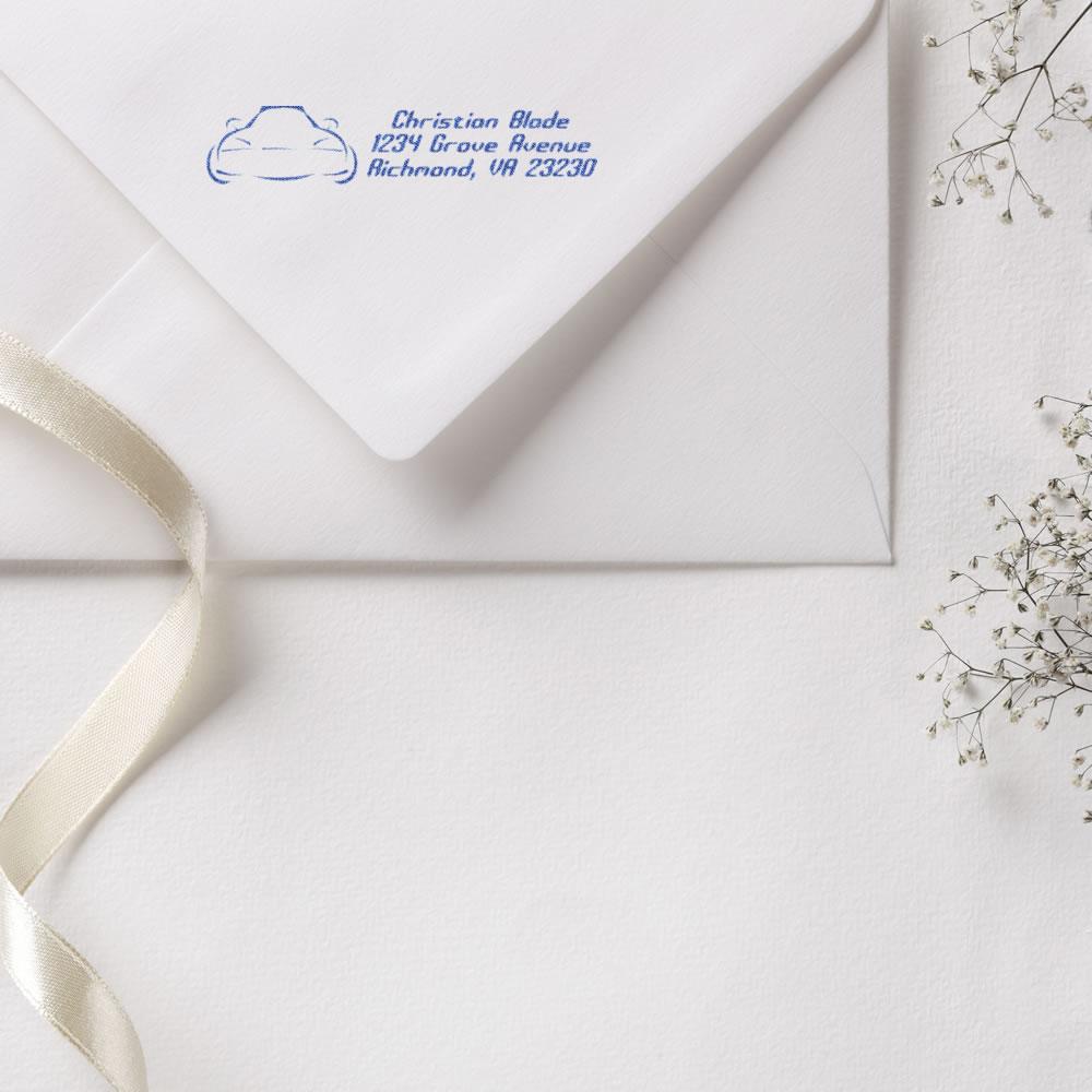Custom return address rubber stamp on a white envelope with blue ink for wedding invitations.