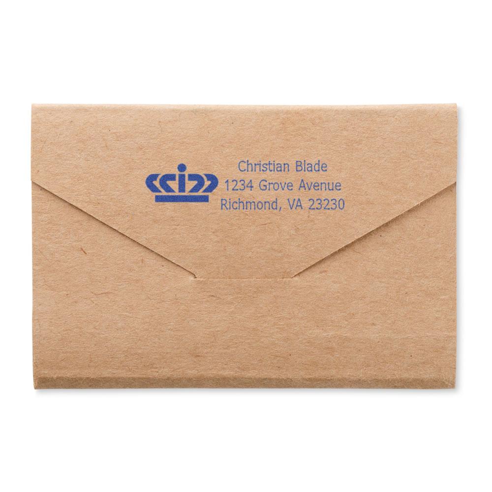 Custom return address rubber stamp on kraft envelope, featuring a blue crown logo and business address.