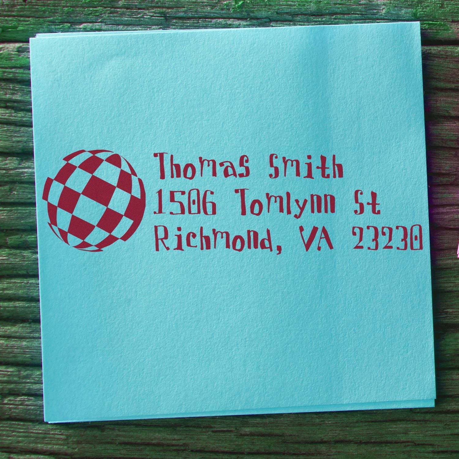 Personalized address rubber stamp for Thomas Smith, Richmond, VA 23230 with logo on a blue envelope.