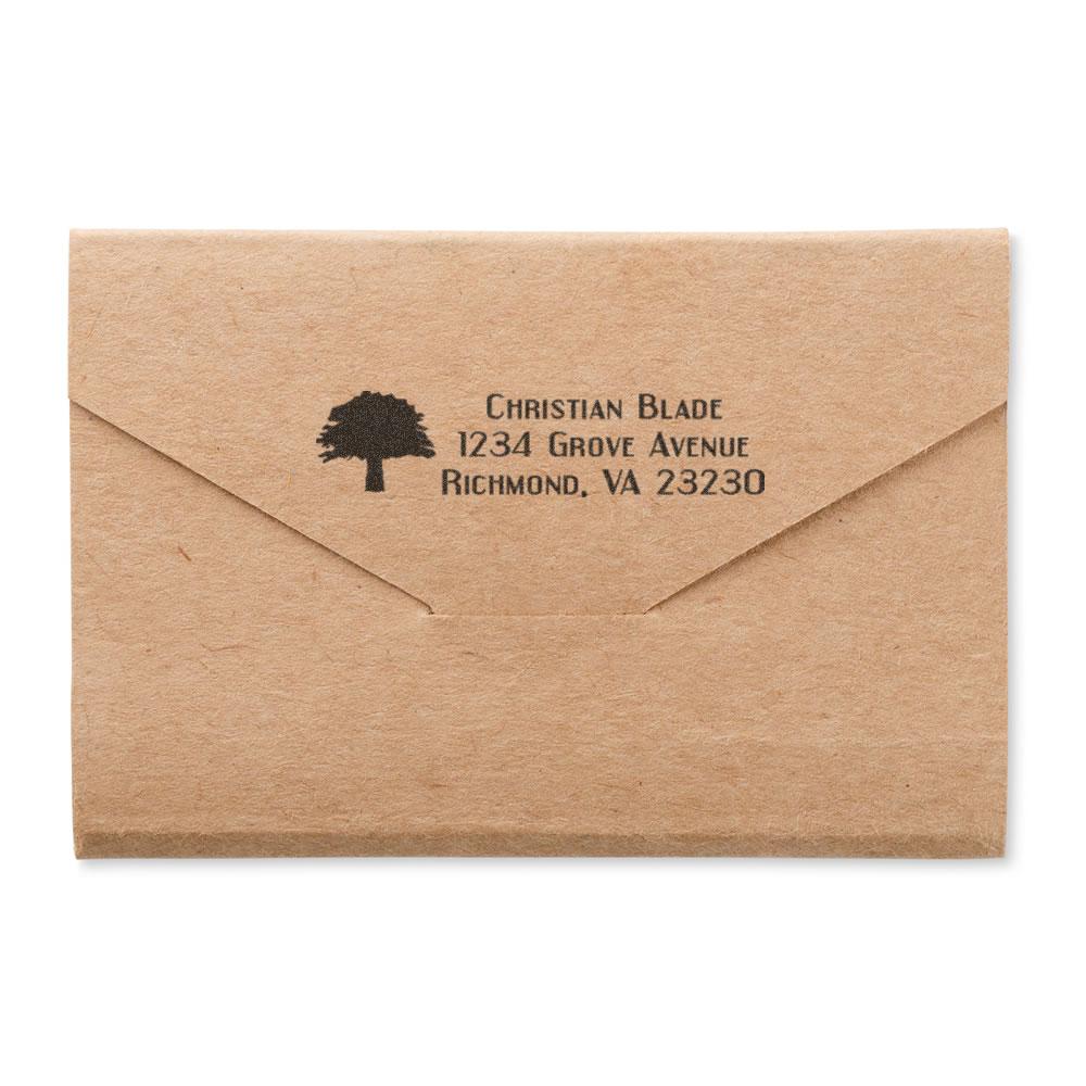 Custom address rubber stamp on kraft envelope with tree logo, ideal for personalized mailings and stationery.