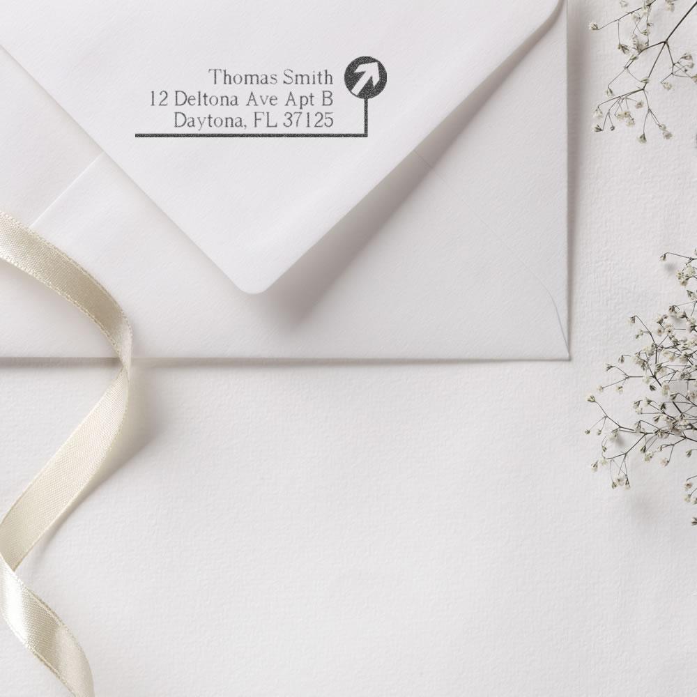Custom return address rubber stamp on wedding envelope for personalized mailing and invitation addressing.