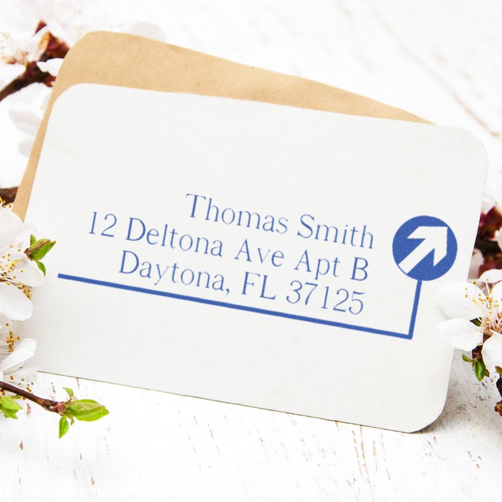 Custom address rubber stamp on envelope with name and mailing address, ideal for personalized return mail.
