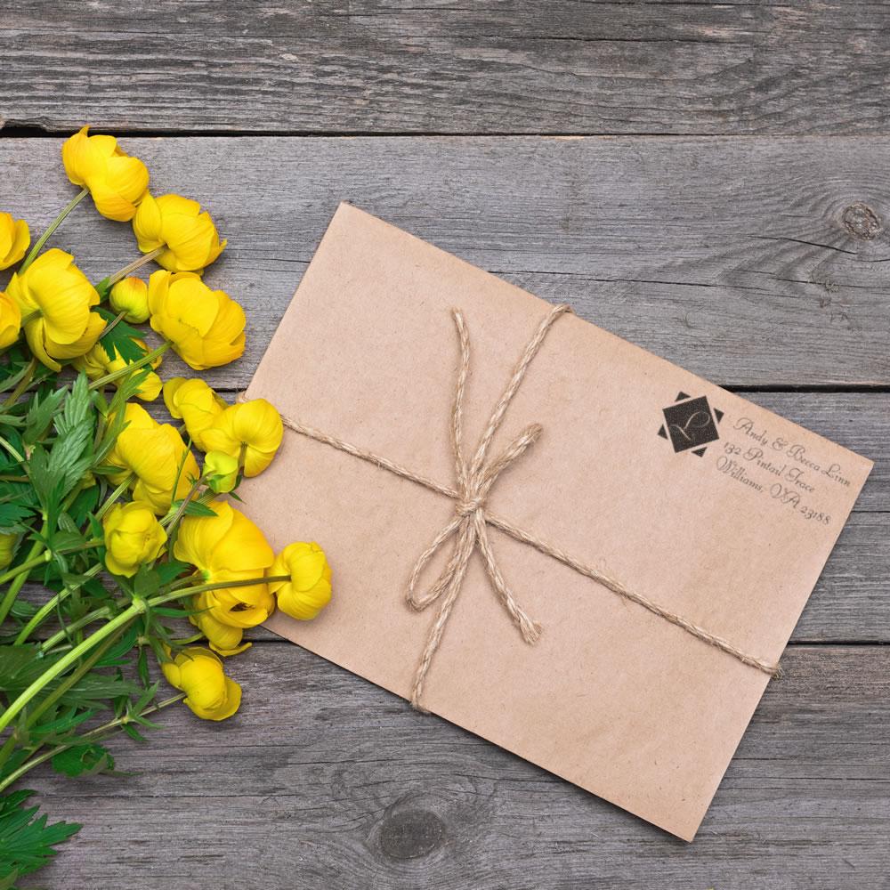 Custom return address rubber stamp on kraft envelope tied with twine for wedding and business stationery.
