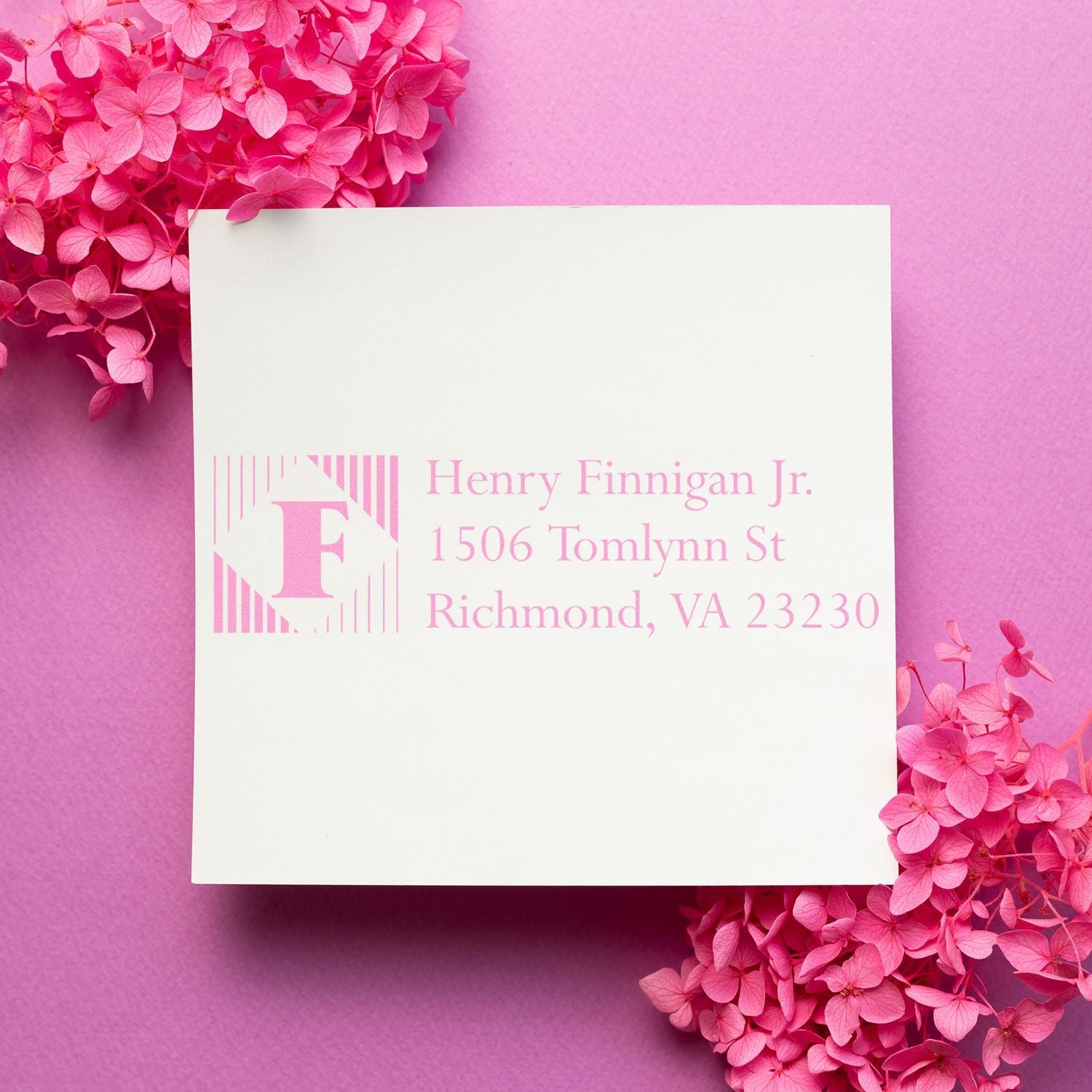 Custom pink monogram return address rubber stamp on white card for personalized stationery.
