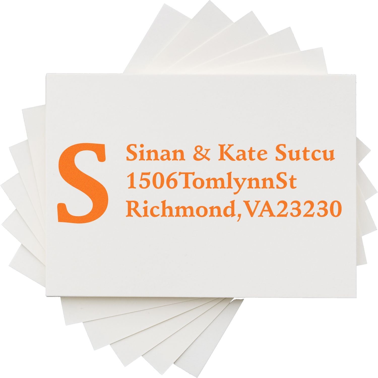 Personalized return address rubber stamp with monogram S and orange ink on folded cards