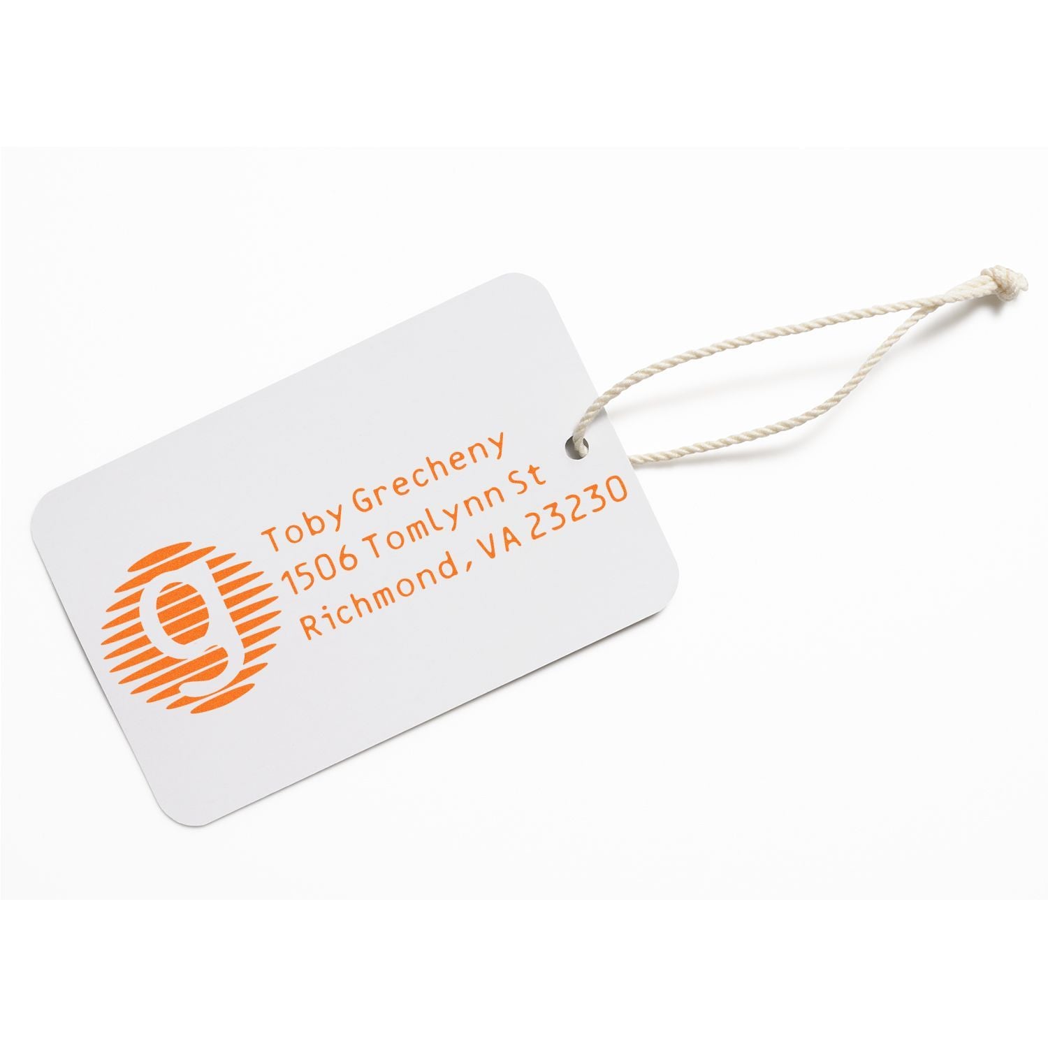 Custom rubber address stamp on white hang tag with orange logo and mailing details for personalized packaging and branding