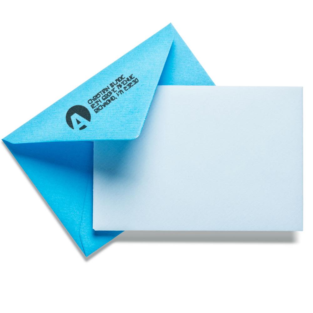 Custom rubber stamp imprint on a blue envelope, showing branded return-address stamping for business mail.