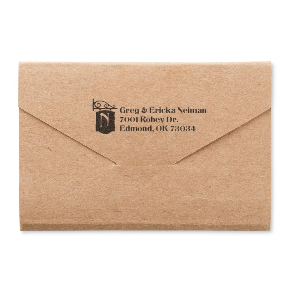 Custom rubber stamp return address on kraft envelope for personalized wedding or business mailing.