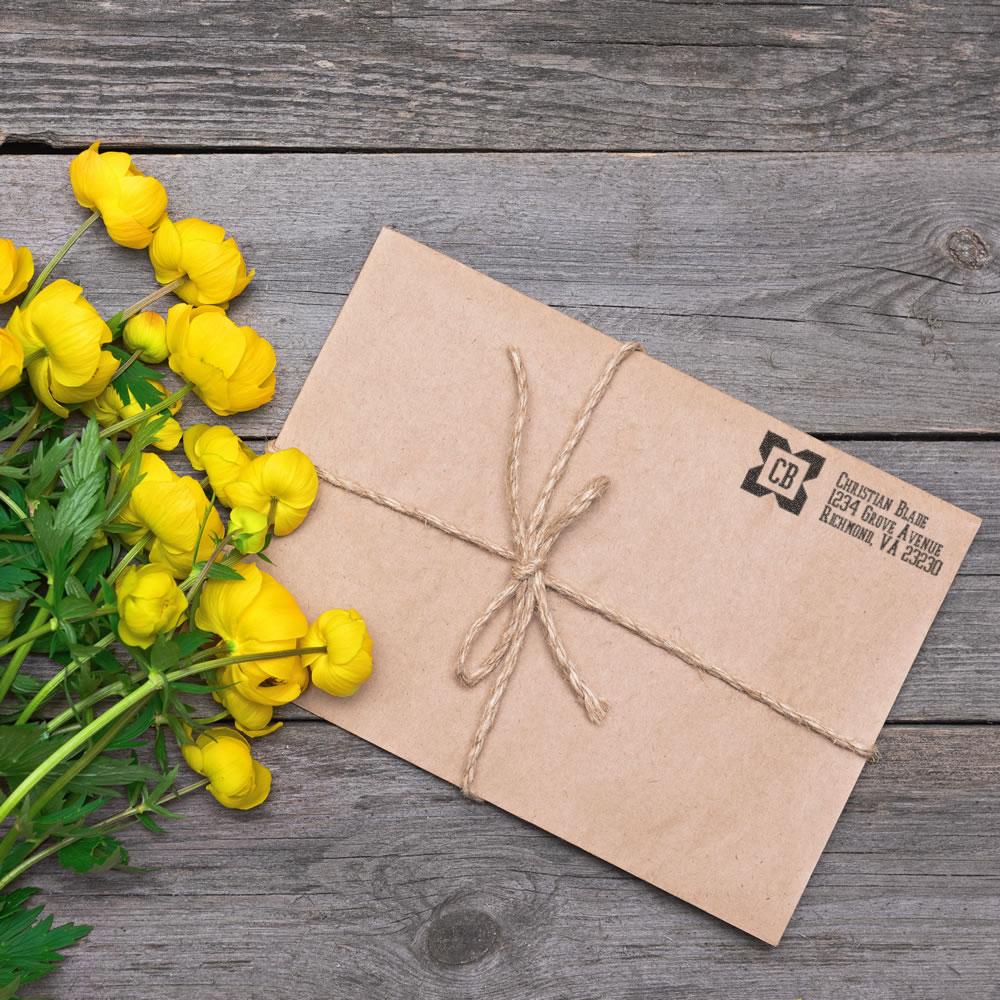 Custom rubber address stamp on kraft envelope tied with twine for rustic wedding invitations or business mailings.