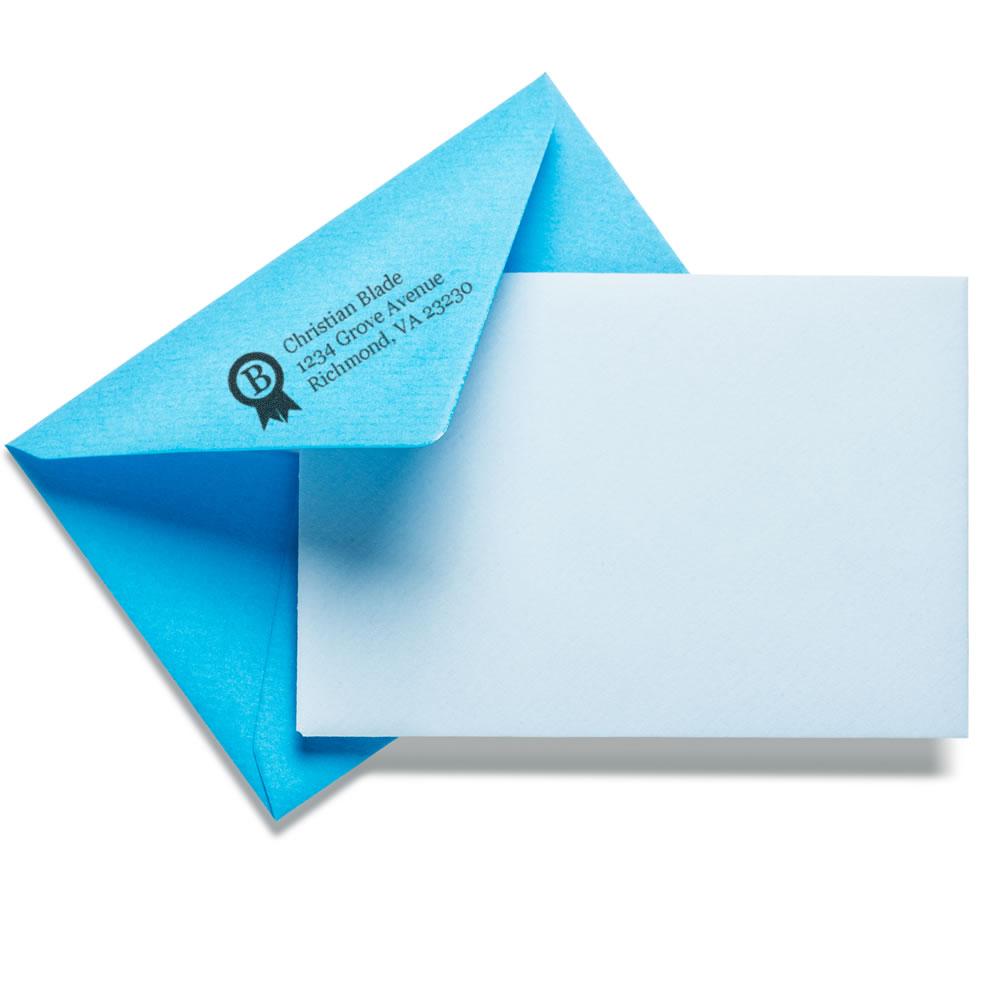 Blue envelope with custom rubber stamp return address imprint, paired with a blank card for personalized business mailings.