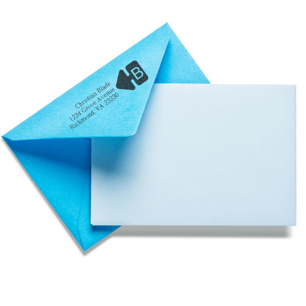 Custom return address rubber stamp on a blue envelope with a blank letter for mailing.