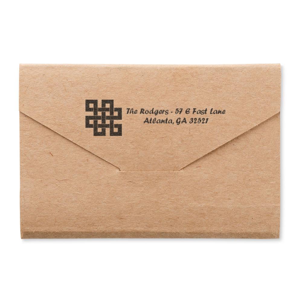 Personalized rubber return address stamp on kraft envelope with monogram logo and custom mailing details for business or personal mail.