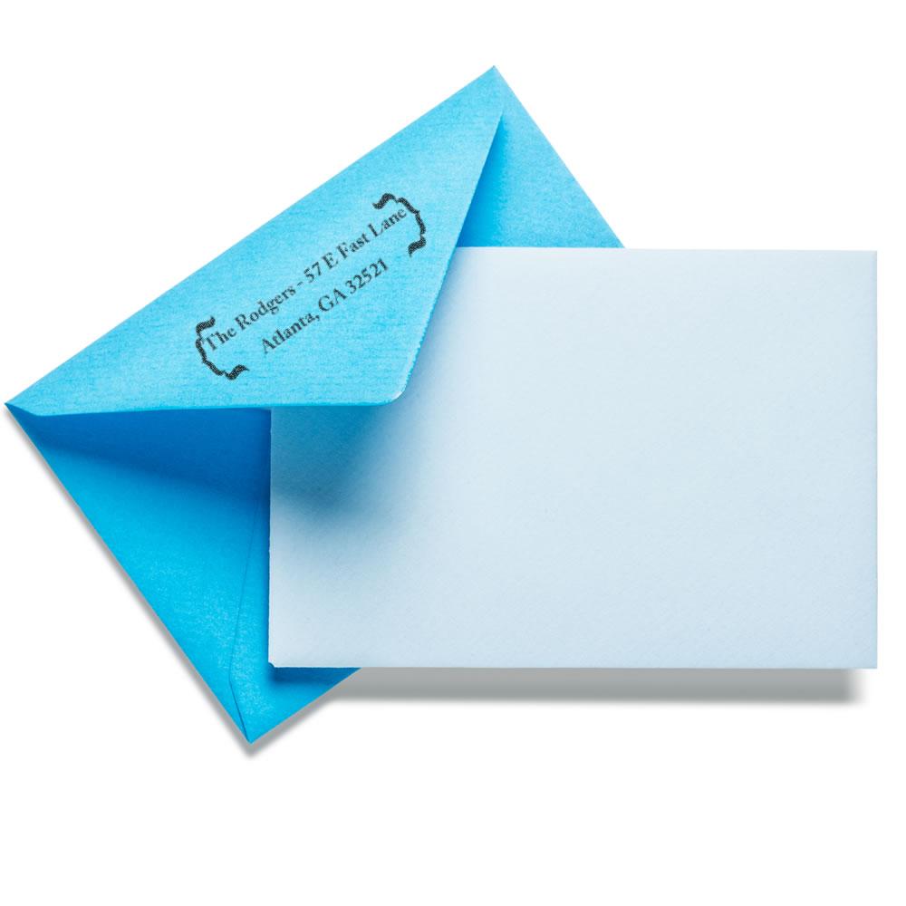 Custom rubber stamp return address on blue envelope with white card for personalized mailing and stationery.