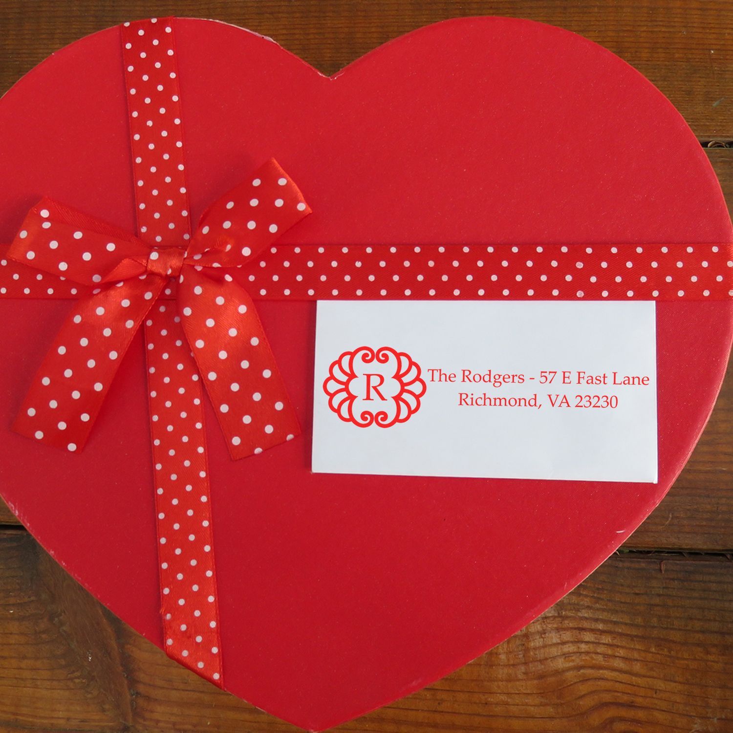 Custom return address rubber stamp on a heart-shaped gift box with ribbon for personalized wedding or Valentine packaging