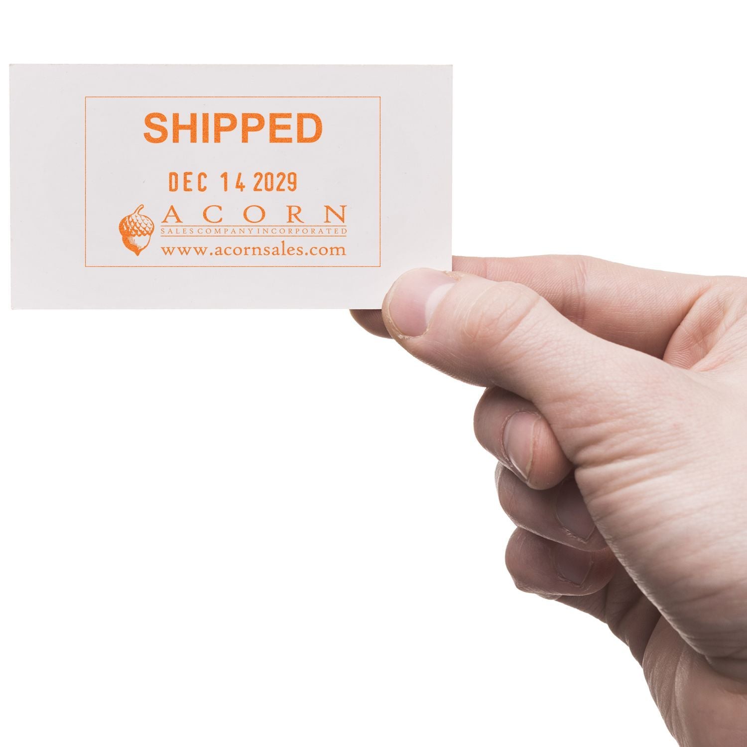 Hand holding a white business card stamped Shipped with Acorn Sales Company logo and date.