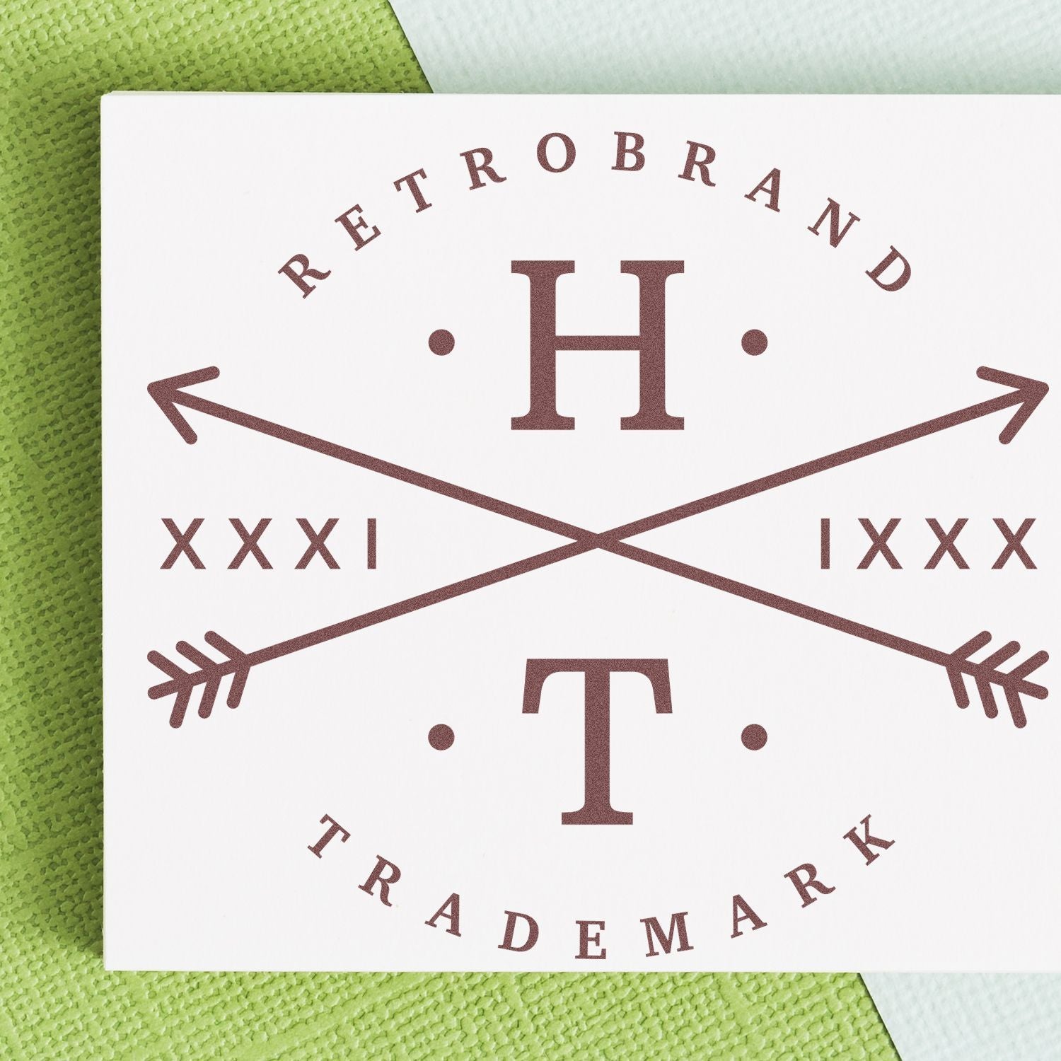 Trademark brand graphic on card: central H with crossed arrows and TRADEMARK text, showing product branding mark