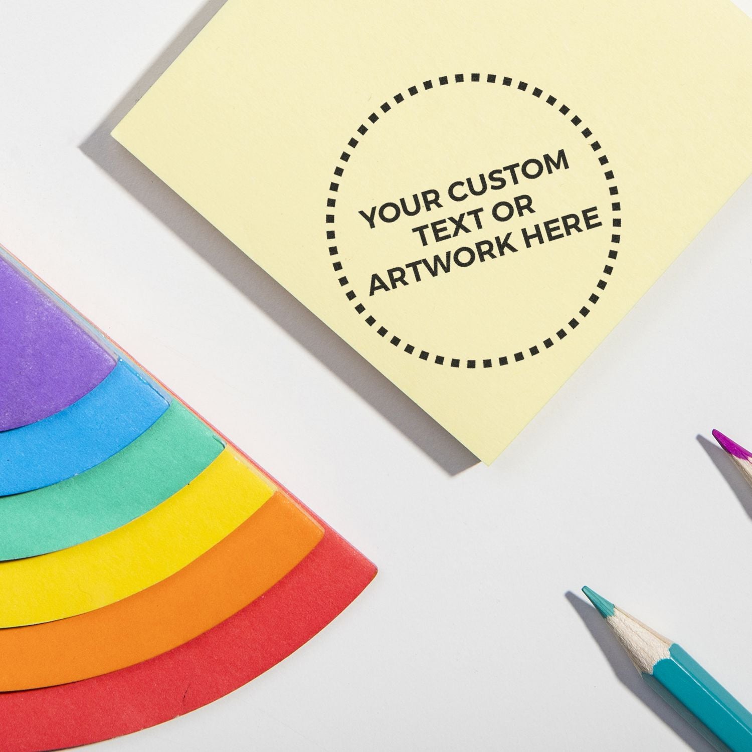 Customizable sticky note mockup with rainbow paper and colored pencils on a white background.