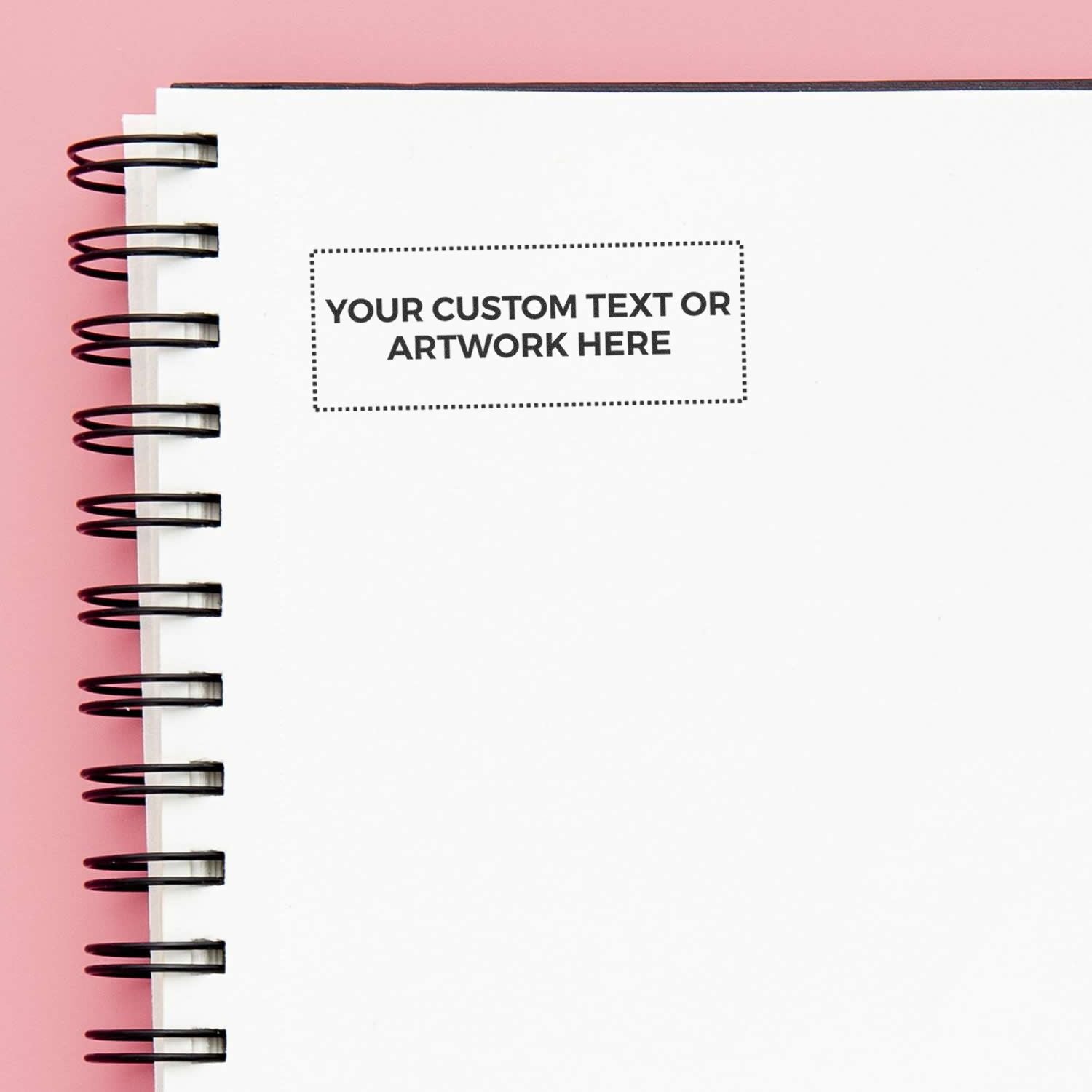 Blank spiral notebook mockup with custom text placeholder on a pink background, ideal for branding, design, and stationery presentation.