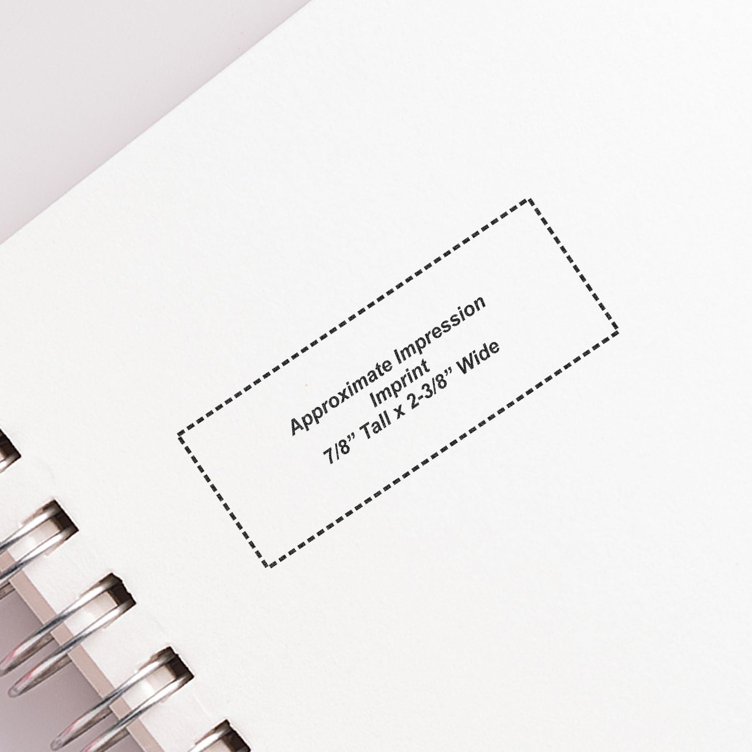 Spiral notebook page showing a dotted imprint area labeled Approximate Impression Imprint 7/8 tall x 2-3/8 wide for custom printing.