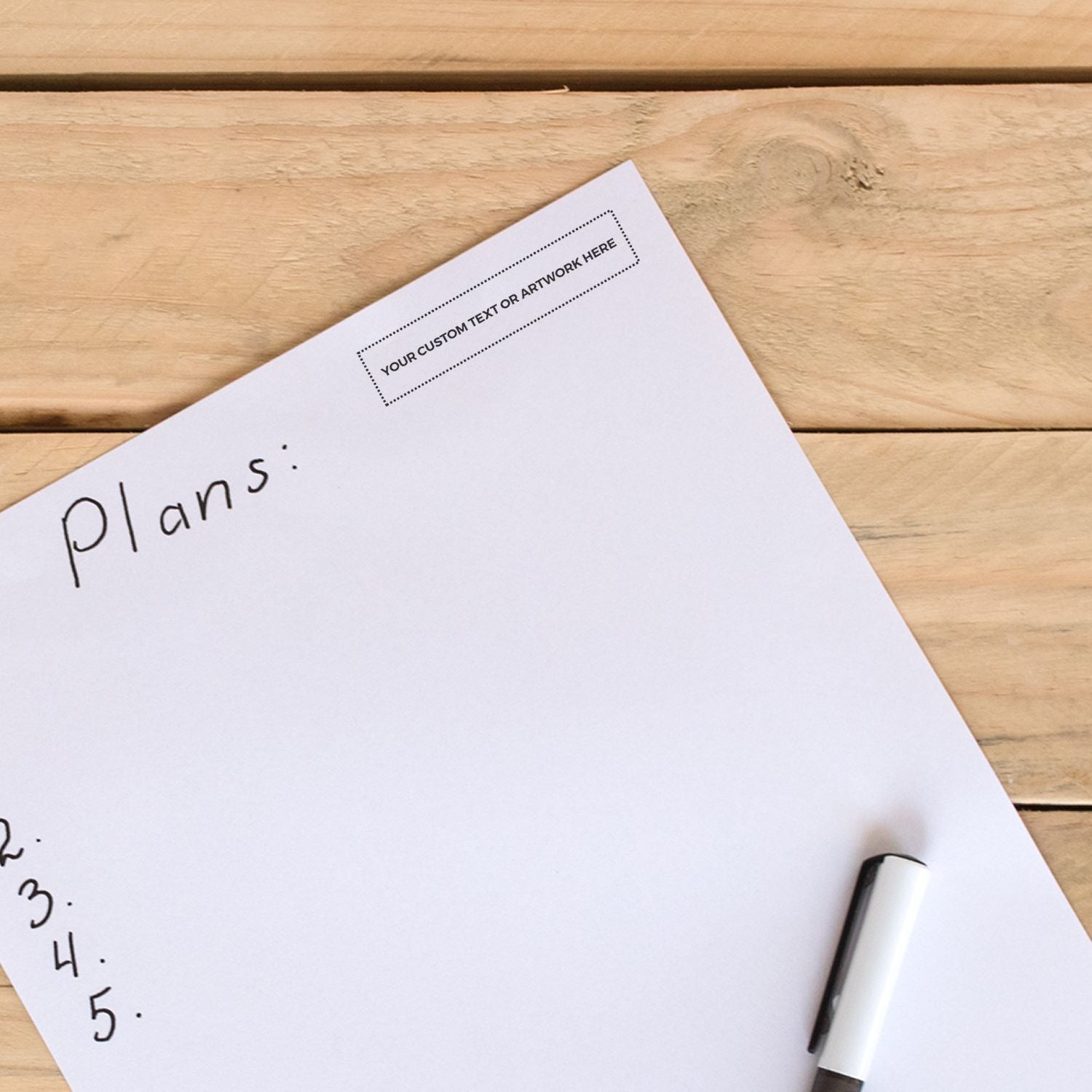 Blank planning sheet with handwritten list on a wooden desk, featuring a customizable text area and marker pen.