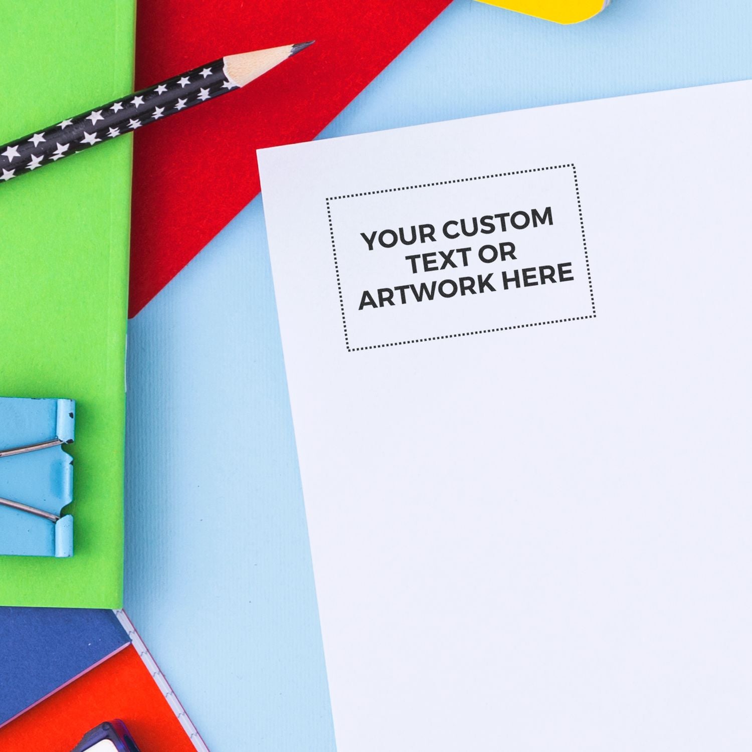 Blank custom text and artwork flyer mockup with colorful stationery and pencil on a bright background.