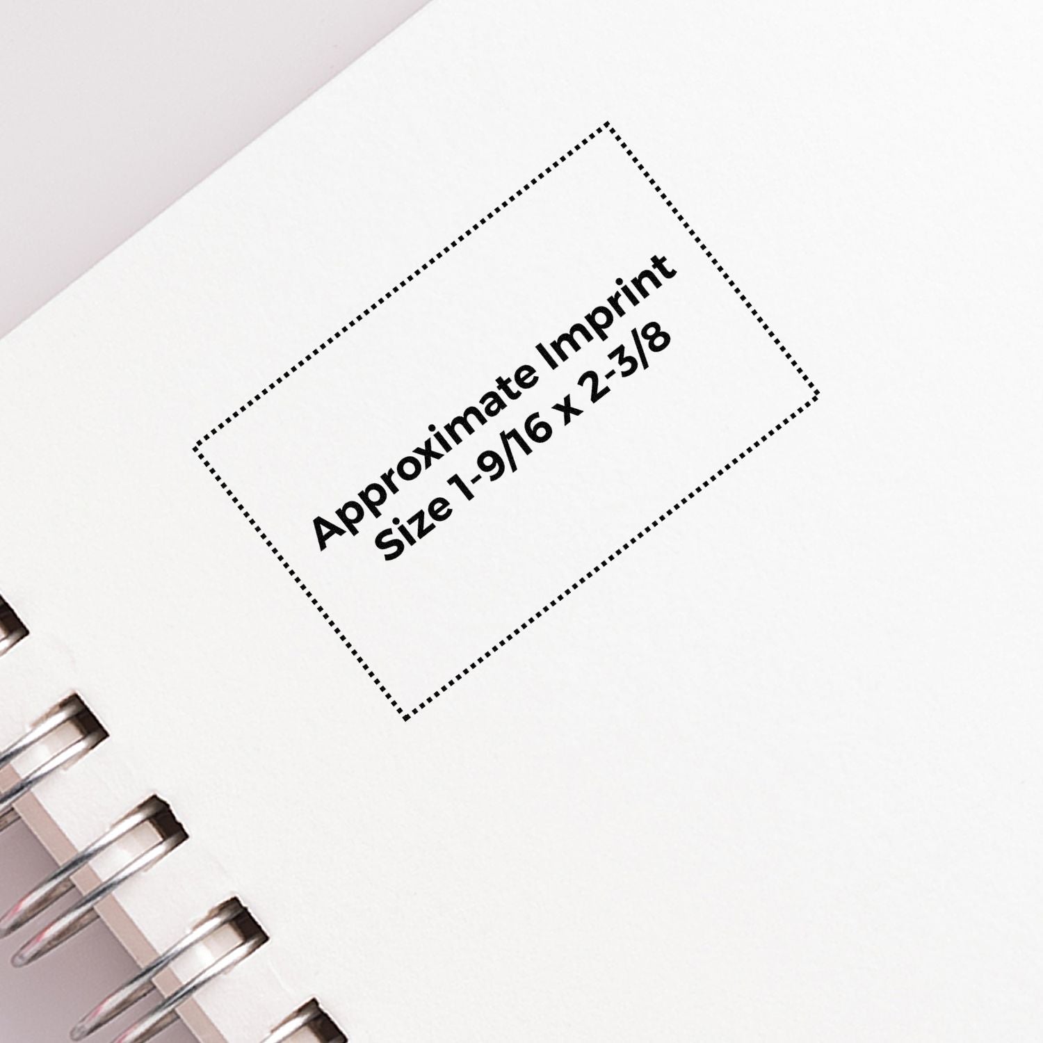 Close-up of a spiral notebook page showing approximate imprint size template 1-9/16 x 2-3/8 for custom branding.